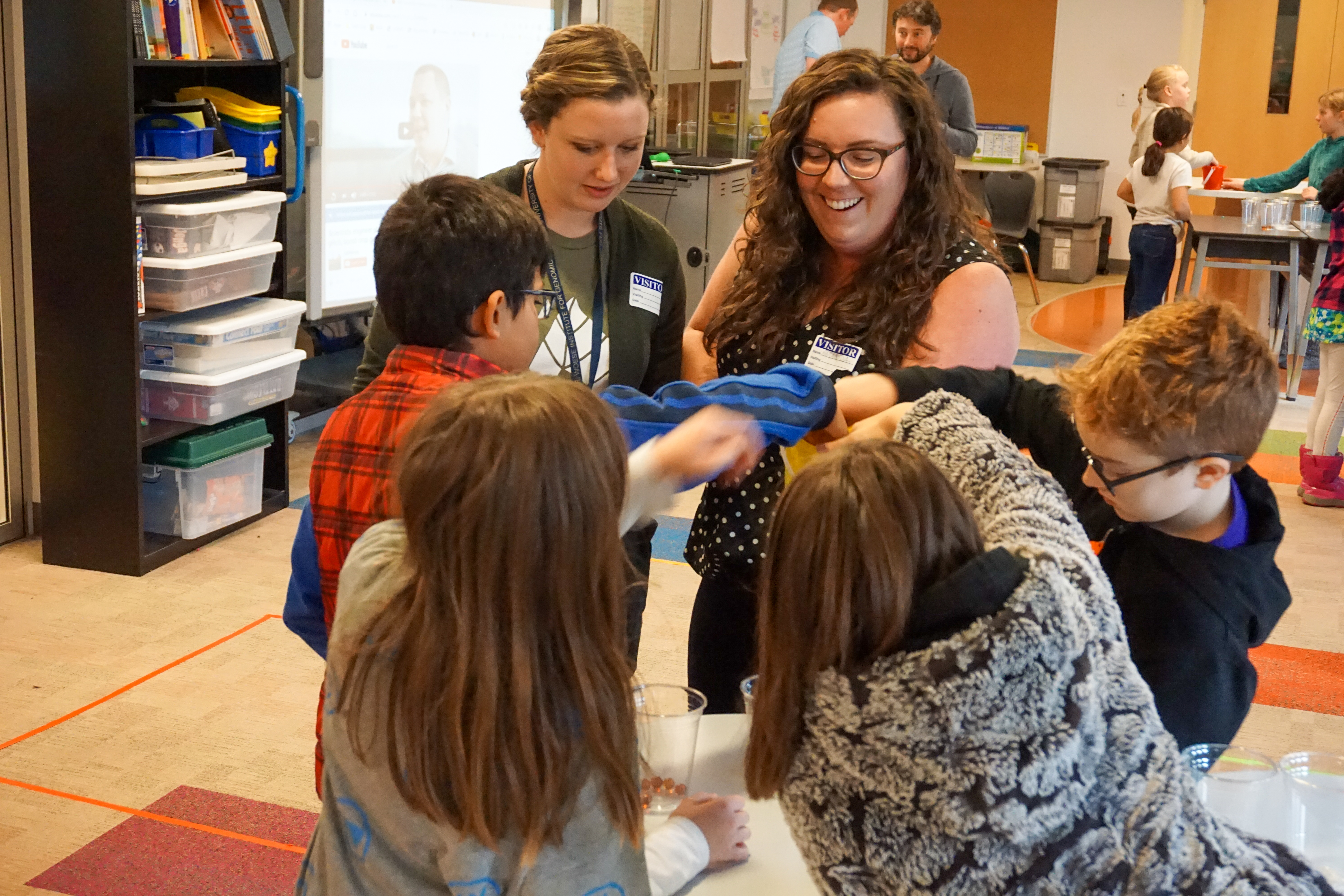 Amanda Cavanagh assists students with an activity to simulate the process of photosynthesis.