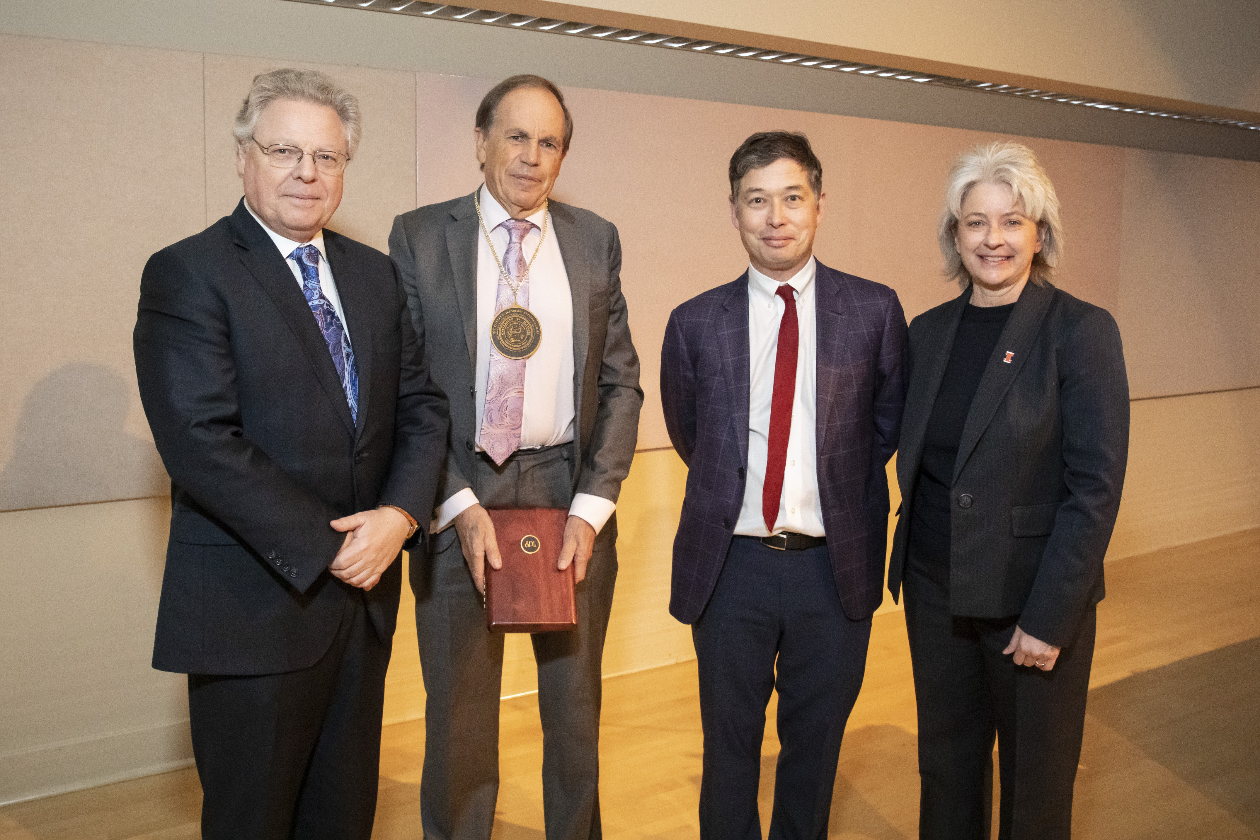 Steve Long wears his medallion and stands with the Provost, Associate Dean Matthew Ando, and Dean Kidwell.