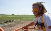 David Drag poses in a cherry picker overlooking the field trials.