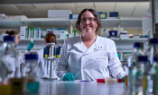 Amanda Cavanagh in a white lab coat in a lab setting.