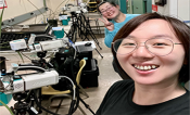Yu Wang front left, with a colleague and research equipment in the background.