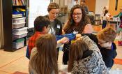 Amanda Cavanagh assists students with an activity to simulate the process of photosynthesis.